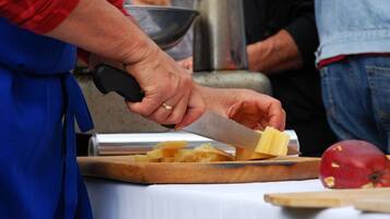 Una persona cortando queso sobre una tabla de madera.