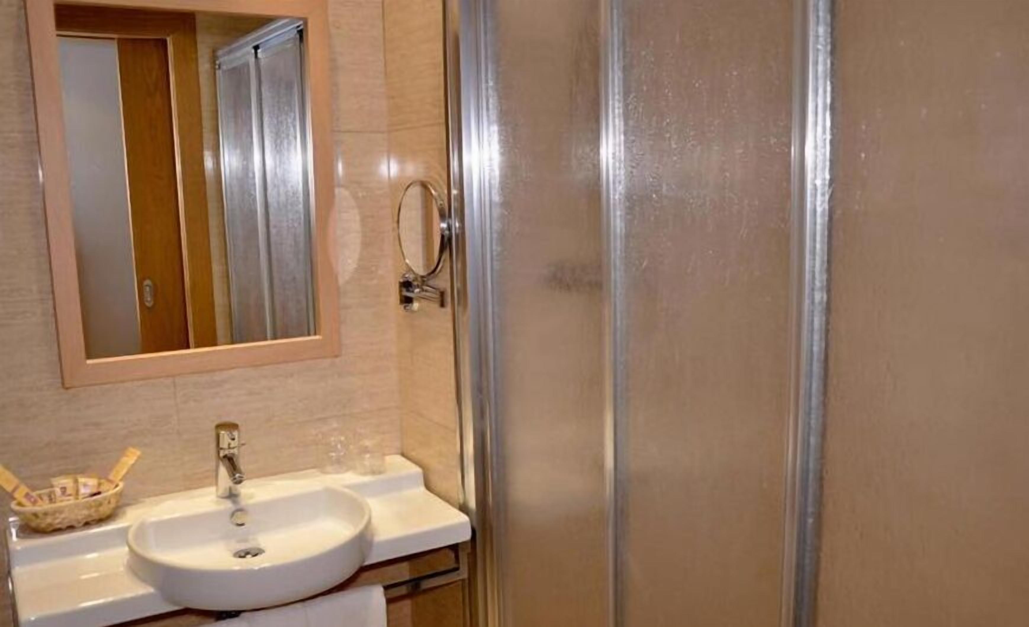 Ein Badezimmer mit Waschbecken, Spiegel und Dusche.