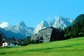 A hotel with a modern design, set against a backdrop of mountains. - Alpina (Kranjska Gora)