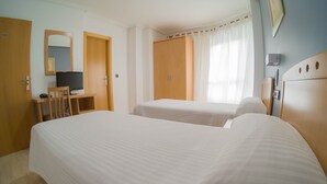 A hotel room with two beds, a desk with a chair, a television, and a wardrobe. - Hostal Meseguer (Elche)