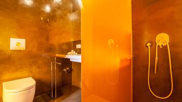 Une salle de bain moderne avec une douche à parois de verre, des toilettes et un lavabo avec un miroir.