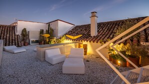 A rooftop terrace with white outdoor furniture, a small bar area, and potted plants. - Hotel Viento10 (Córdoba)