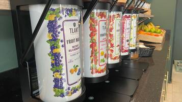 Varias máquinas dispensadoras de zumo de frutas, con etiquetas que indican distintos sabores.