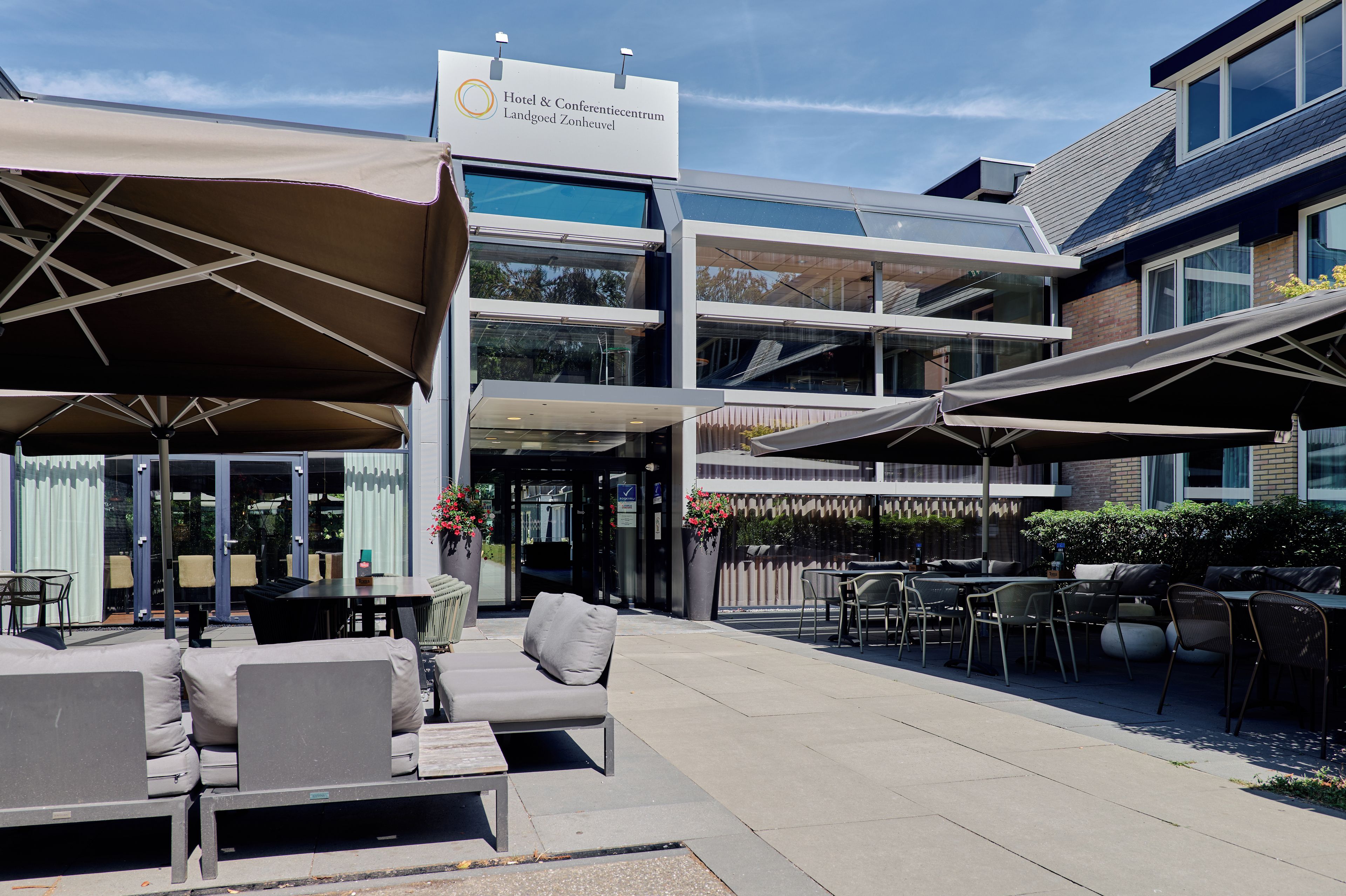 A hotel with outdoor seating and a sign indicating it is a conference center.
