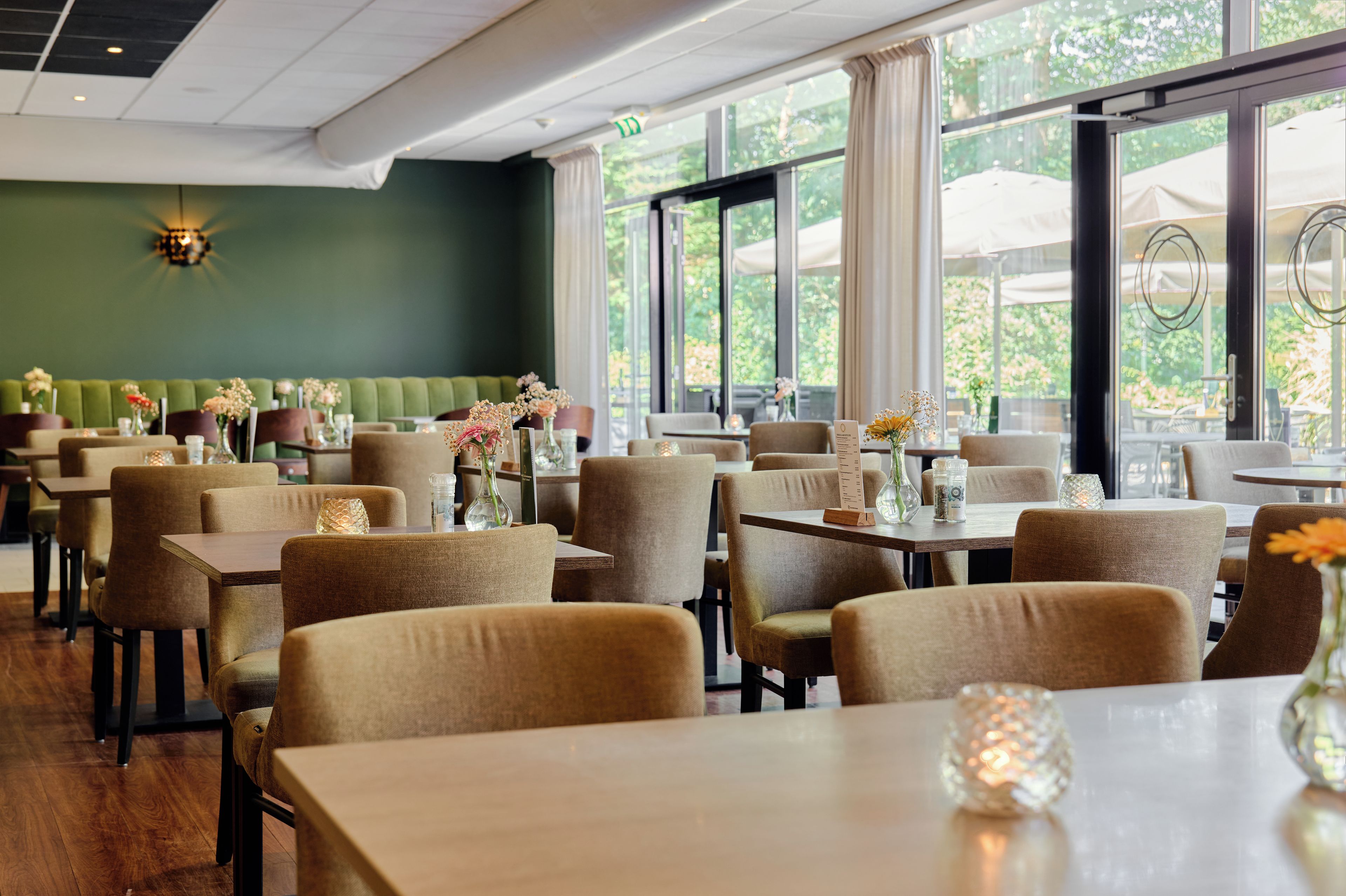 A restaurant interior with booths, tables, and a green wall.
