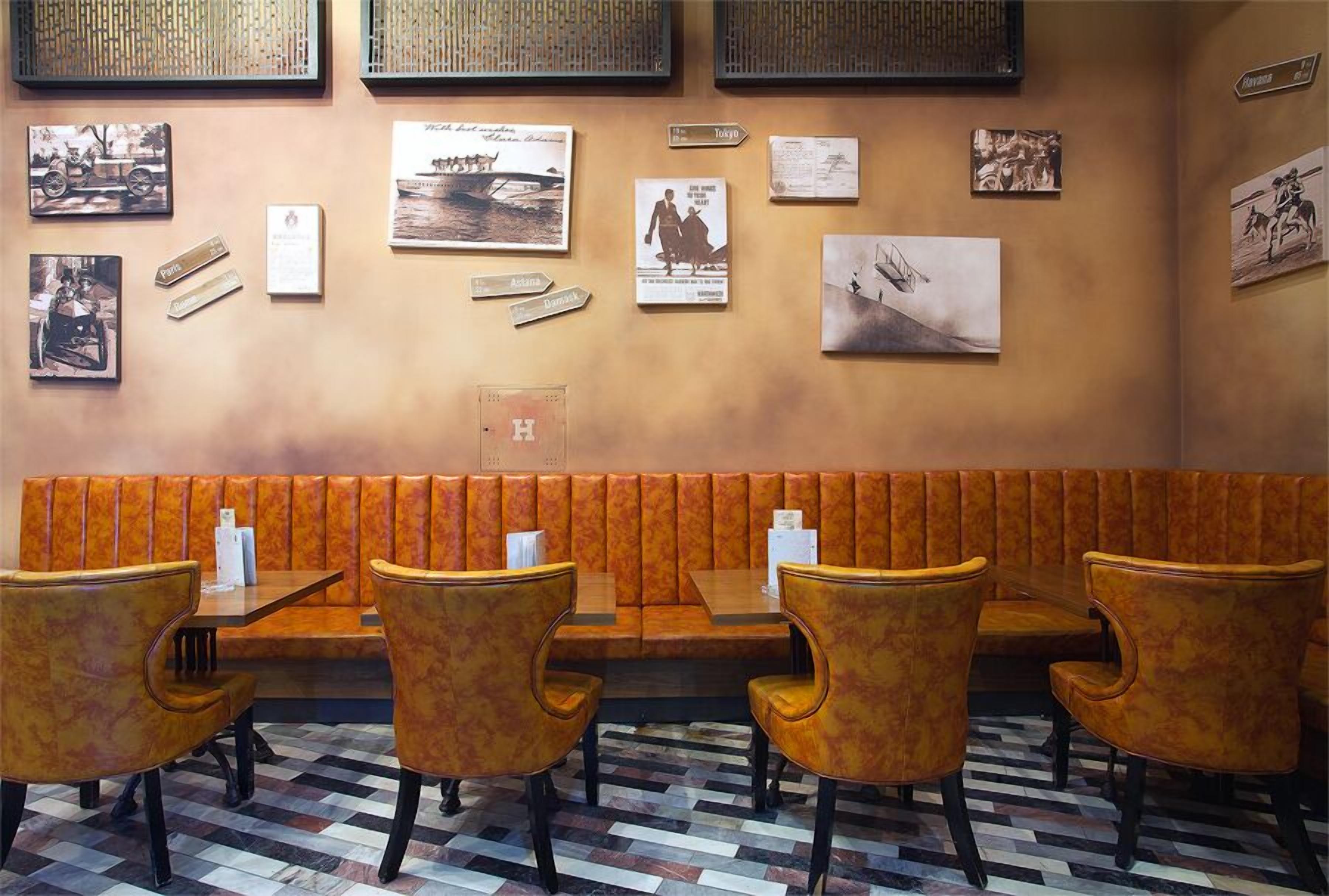 A restaurant with booths and tables, a patterned floor, and wall decorations including photographs and signs.