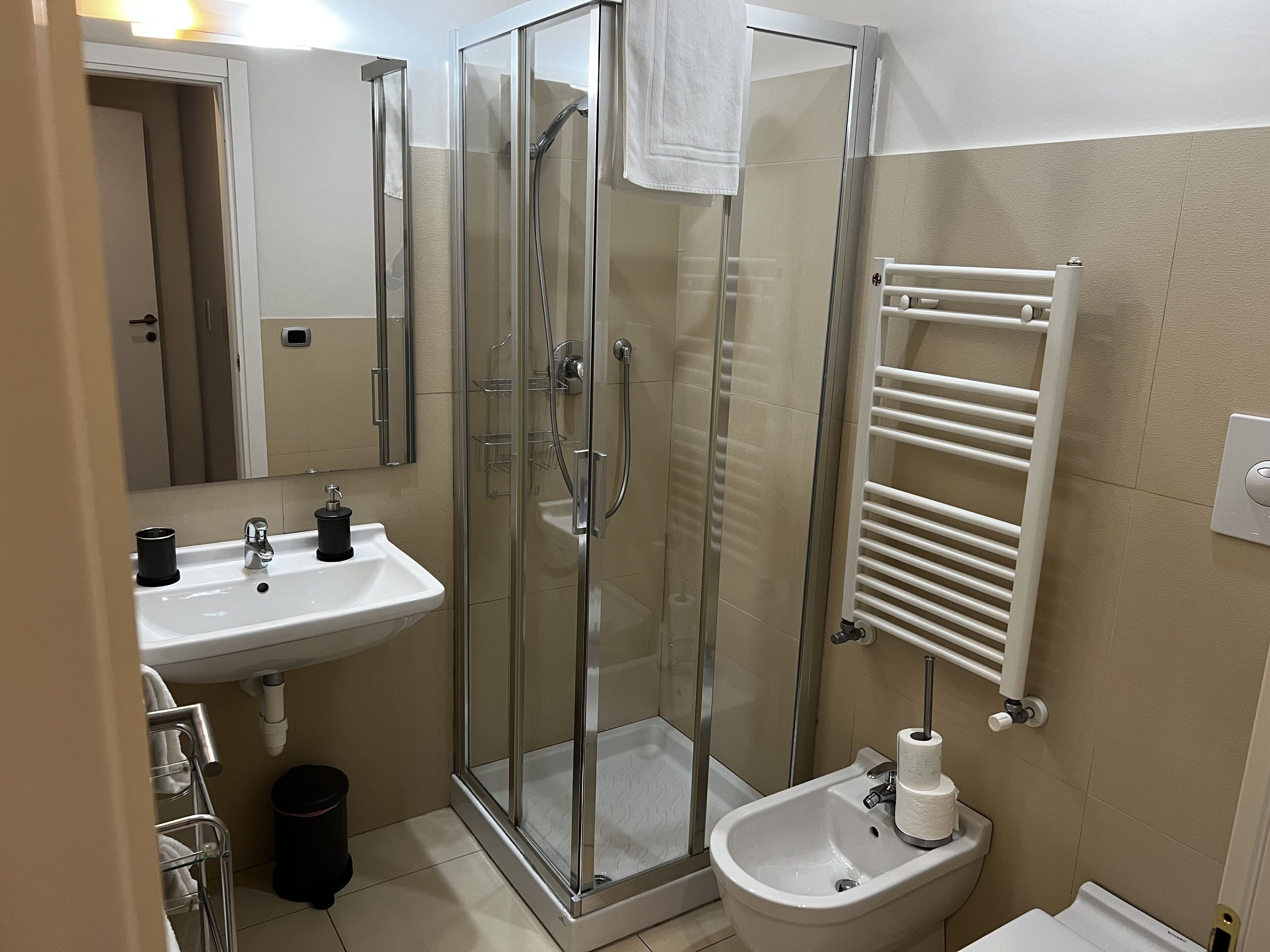 Un baño moderno con ducha acristalada, lavabo e inodoro.