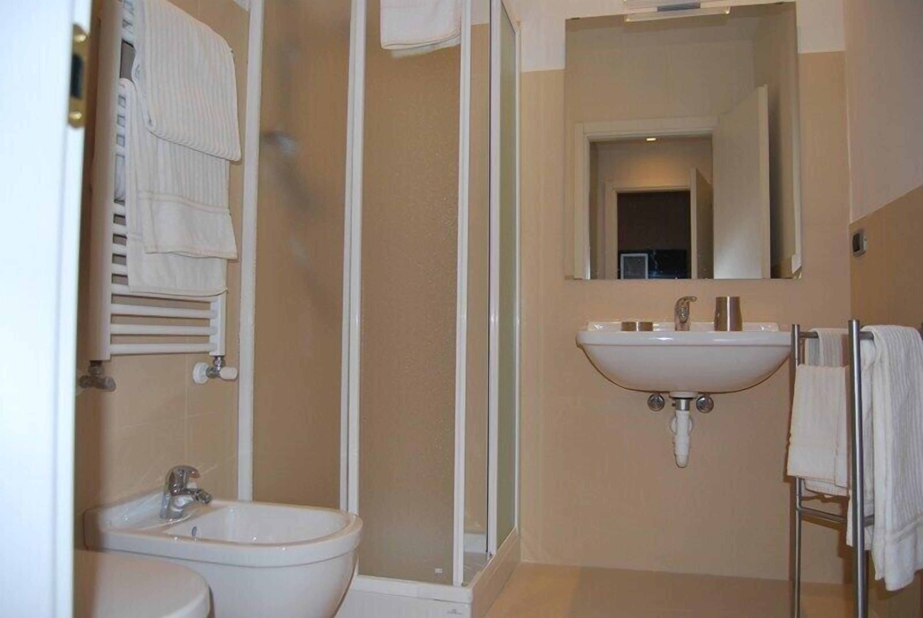 A bathroom with a toilet, bidet, and sink.