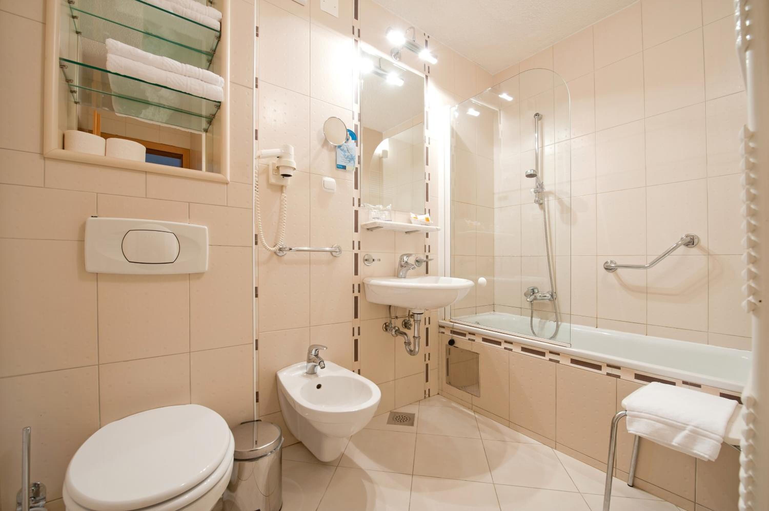 Un baño moderno con bidé, lavamanos, bañera y retrete.