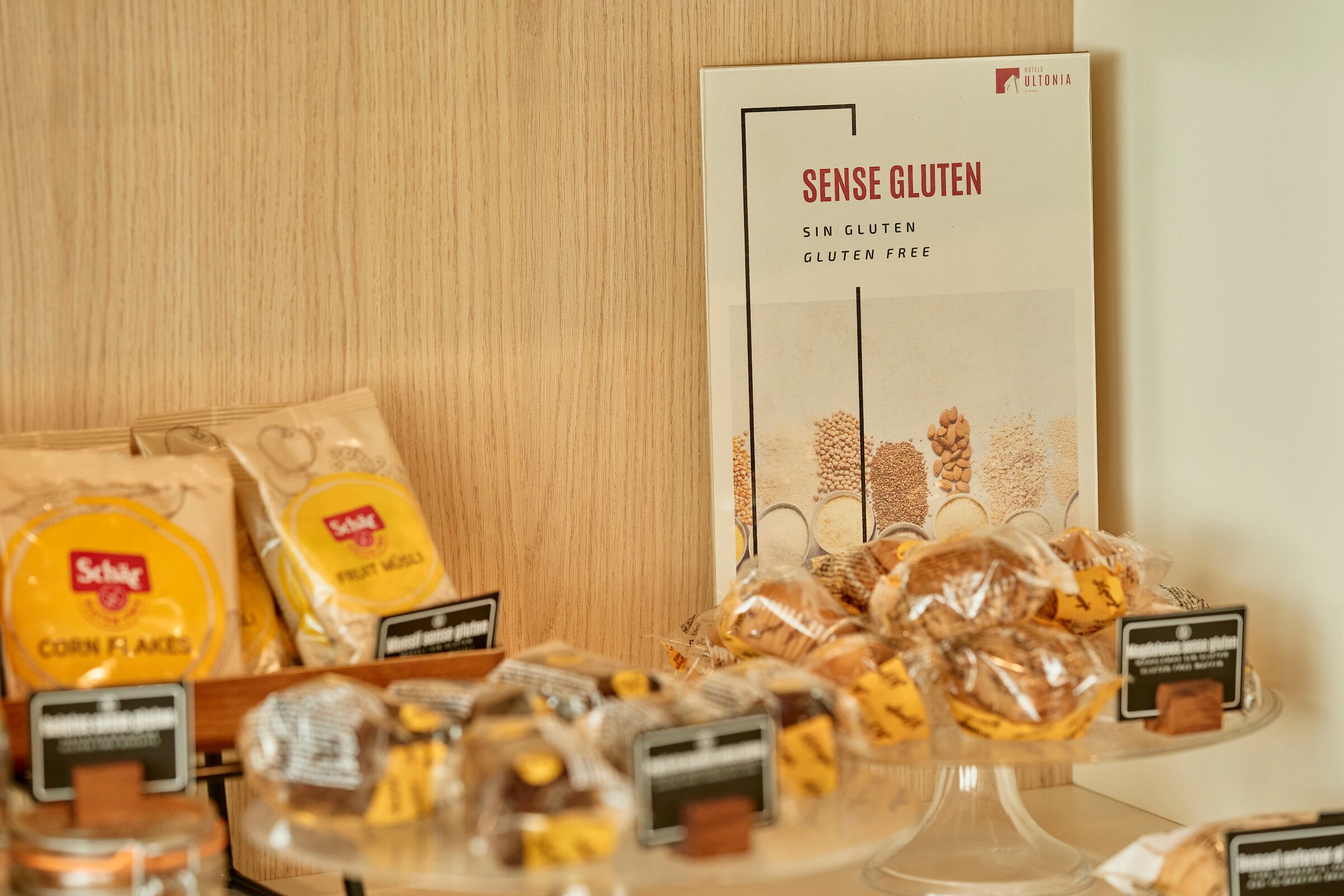 A display of gluten-free products including corn flakes and a sign for 'Sense Gluten' gluten-free items.