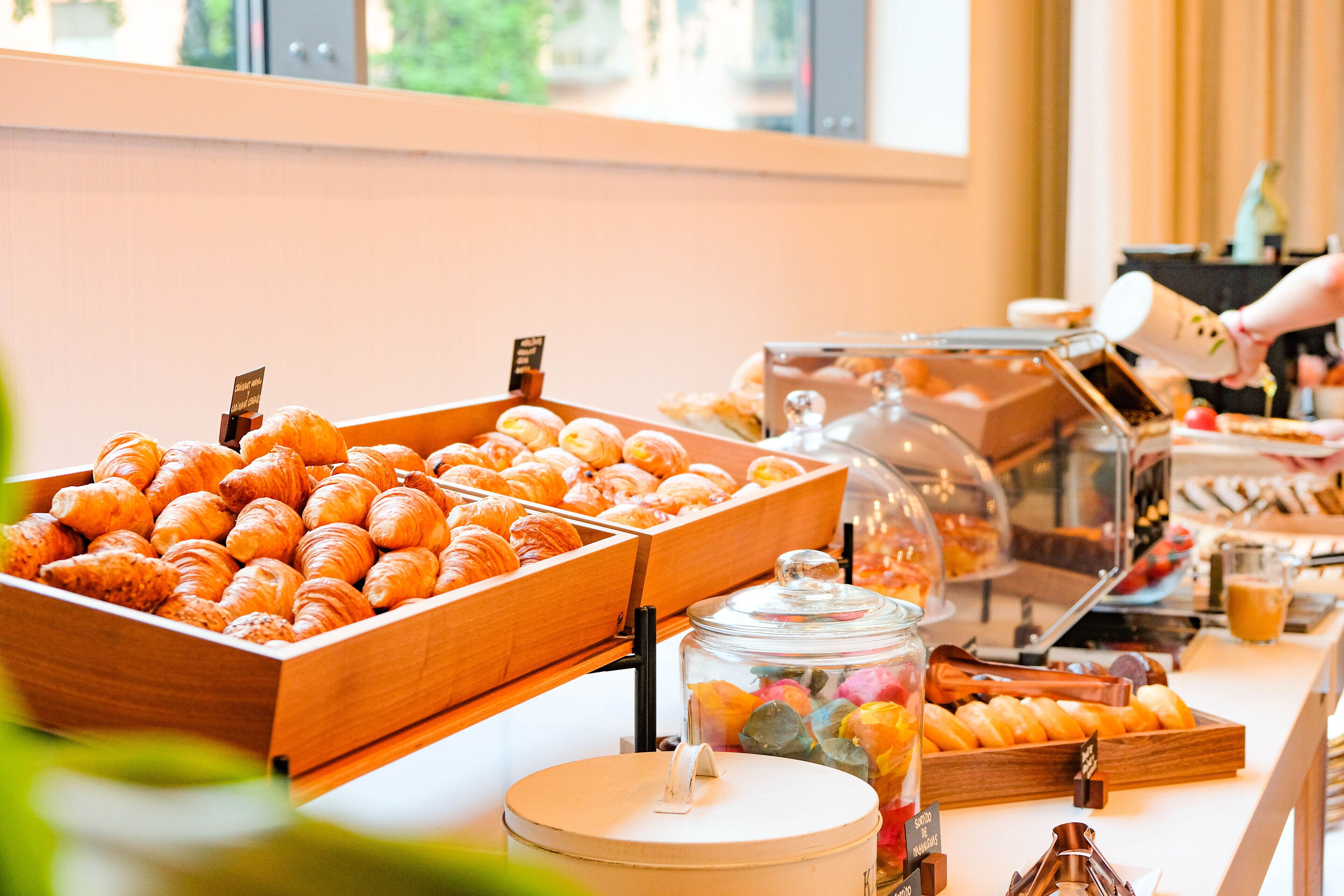 Un bufé de desayuno con diversos pasteles y una estación de café.