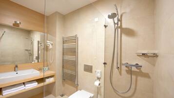 A modern bathroom with a sink, toilet, and walk-in shower.