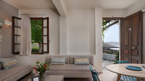 Una sala moderna con sofá, una mesa de comedor y sillas. Hay una ventana con cortinas y vistas al exterior.