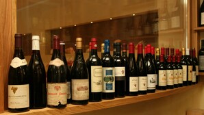 A row of wine bottles on a shelf.