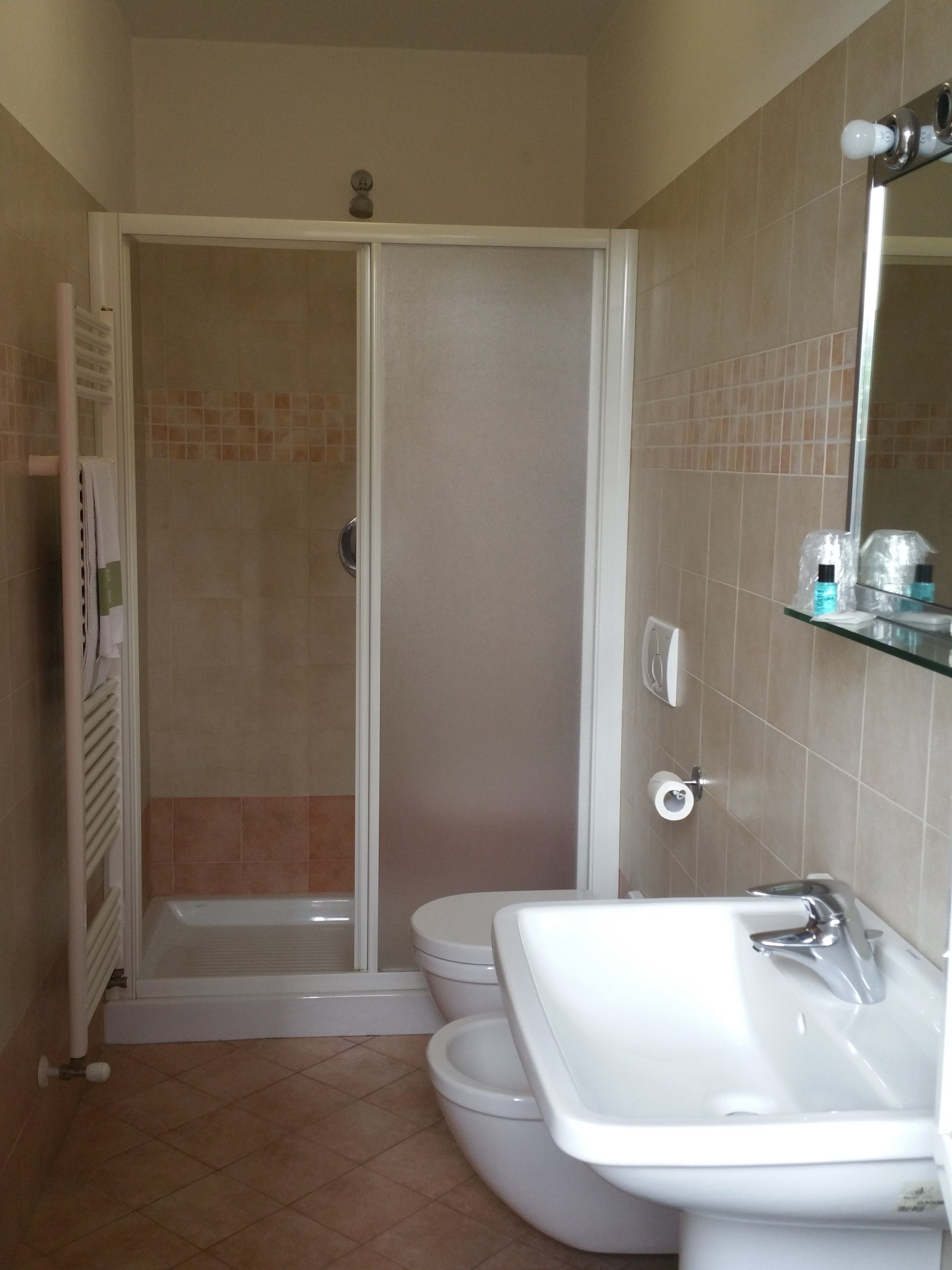 Un baño con ducha, inodoro y lavabo.