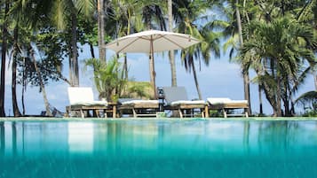 Una piscina al aire libre, sombrillas