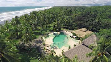 Una piscina al aire libre, sombrillas, sillones reclinables de piscina