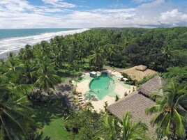 Una piscina al aire libre, sombrillas, tumbonas