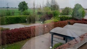 A view from a window overlooking a landscaped garden with a paved pathway, a bench, and a gazebo. - Raya Hotel Motel (Mediglia)