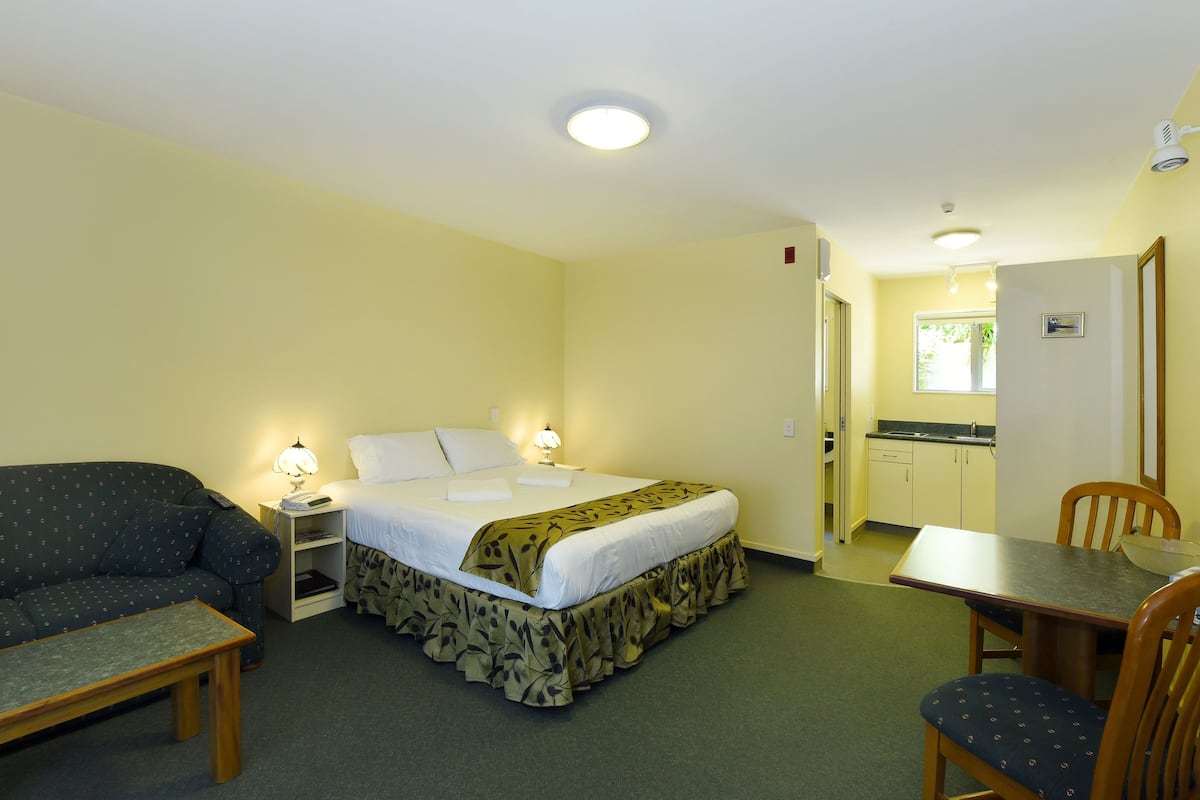 Una habitación de hotel con una cama, un sofá, una mesa y una silla.