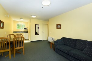 A compact living space with a dining area, kitchenette, and a sofa.