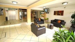 A lobby with two sofas, a small table, and a television on the wall. - Hotel Posada del Carmen (Veracruz)