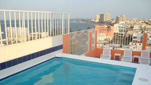 A rooftop pool with a view of a cityscape and the sea. - Hotel Posada del Carmen (Veracruz)