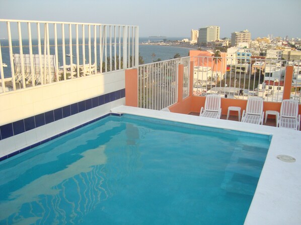 Alberca al aire libre y camastros 