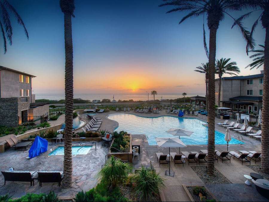 Una piscina al aire libre, camas de piscina con cargo, sombrillas