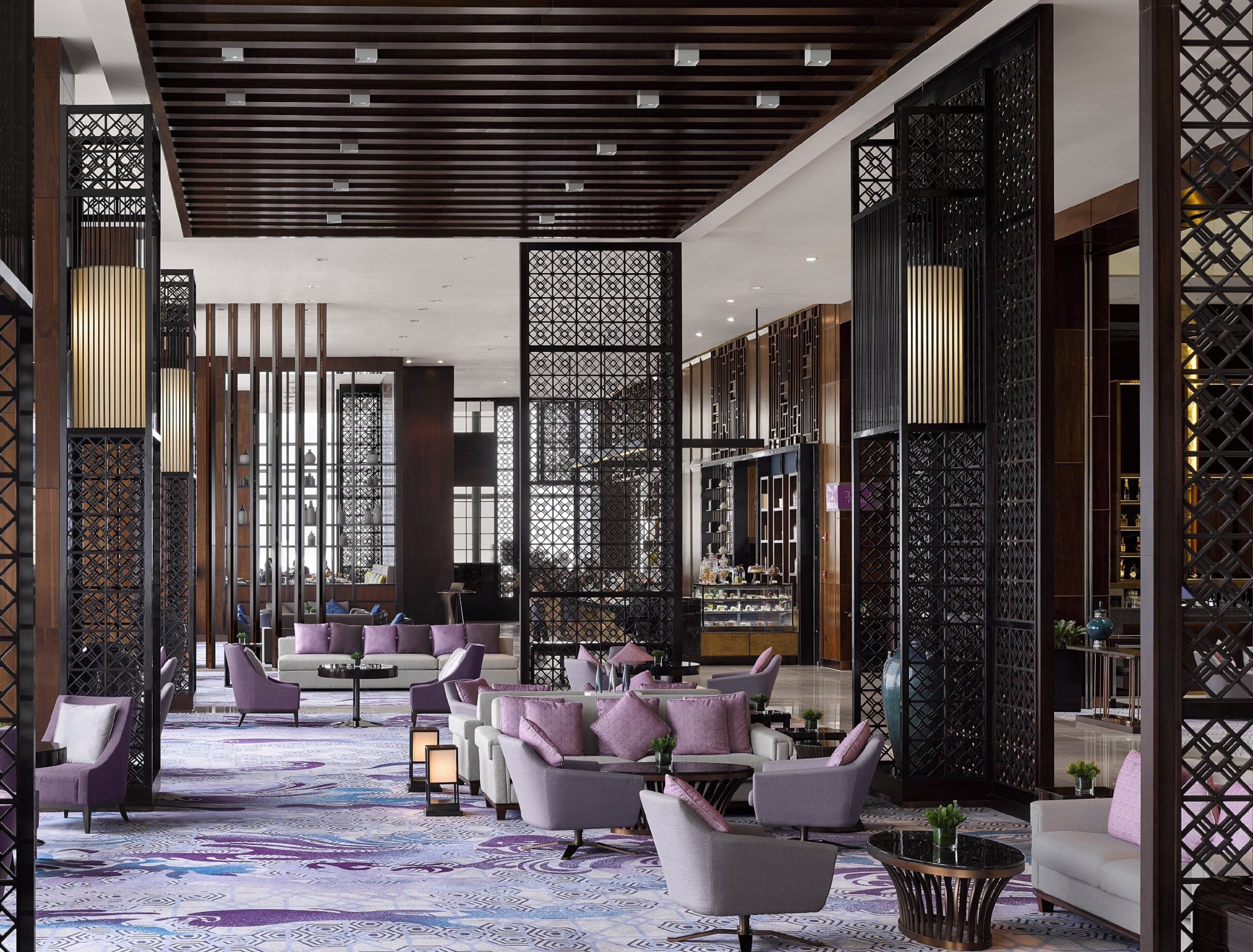 A modern interior with a seating area, decorative screens, and a patterned floor.