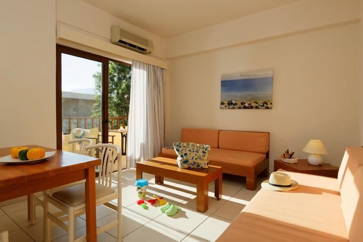 Ein Zimmer mit Esstisch, einer Couch, einem Couchtisch und einem Bild an der Wand.