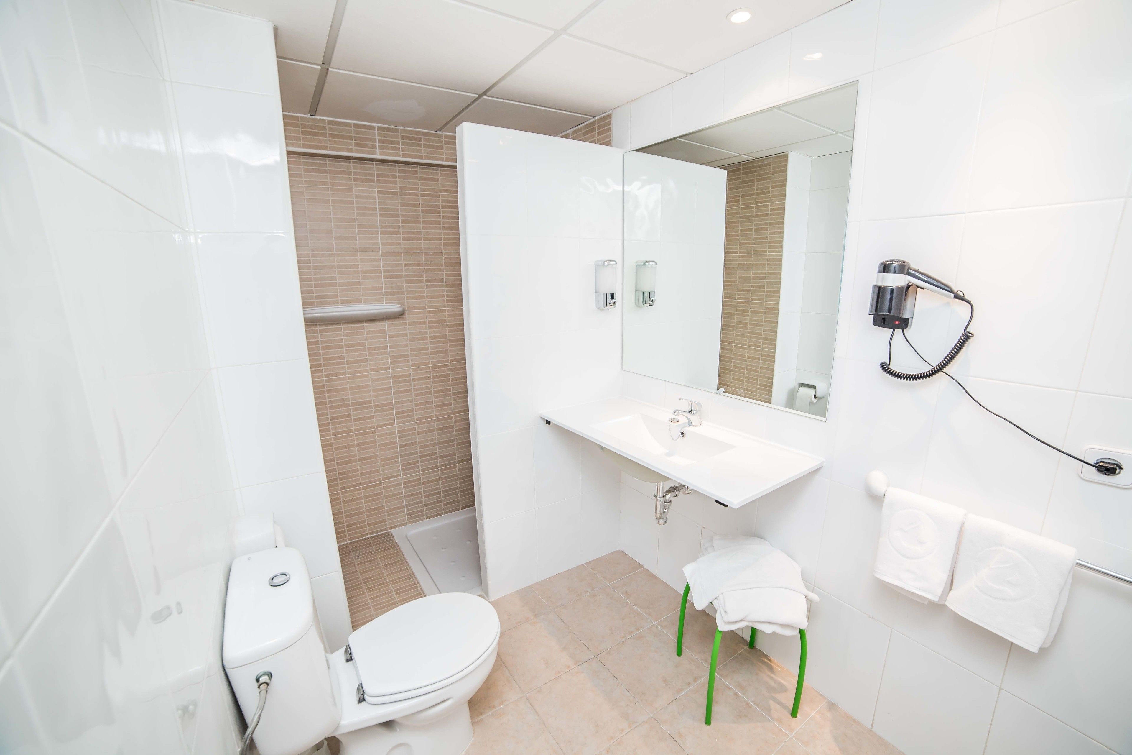 Un baño moderno con inodoro, lavabo y ducha.