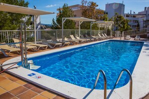 Una piscina con lettini e una postazione di salvataggio.