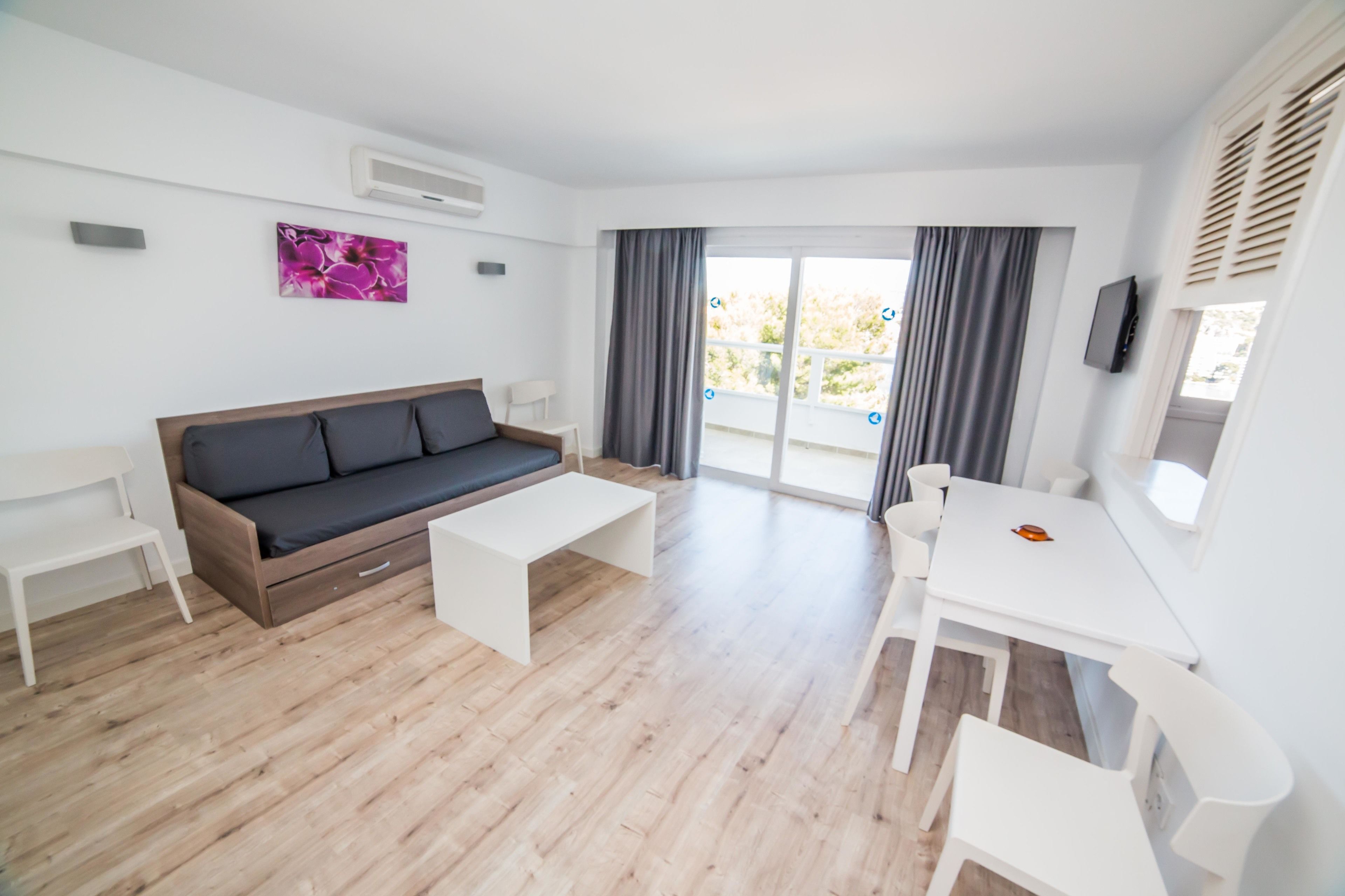 Una sala moderna con sofá, mesa de centro y mesa de comedor.