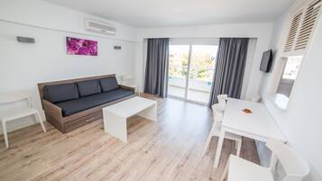 Una sala moderna con sofá, mesa de centro y mesa de comedor.