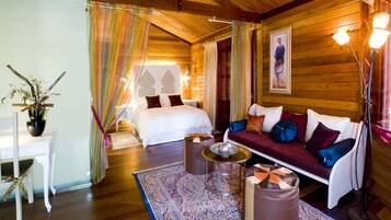Una habitación acogedora con cama, sofá, mesa de centro y sillón.