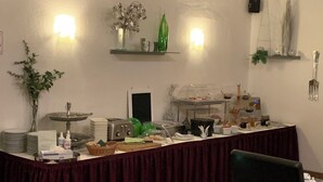 A buffet setup with a variety of food items and a decorative plant. - Hotel Sechzehn (Leverkusen)