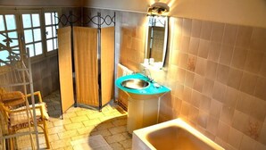 Casa de banho com banheira, lavatório e zona de duche.