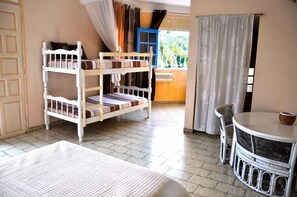 A room with a bunk bed, a small table with chairs, and a view of the outdoors. - Cap Sud Caraïbes Hôtel (Le Gosier)
