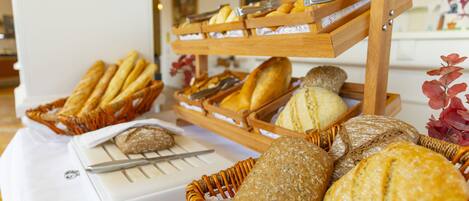 A buffet table with various breads and pastries.