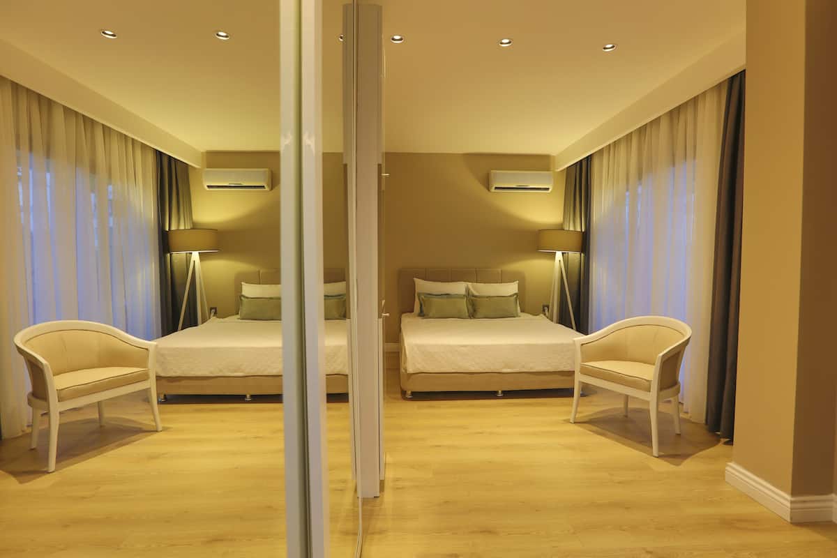 Een kamer met spiegel, een bed, twee stoelen en een spiegel.