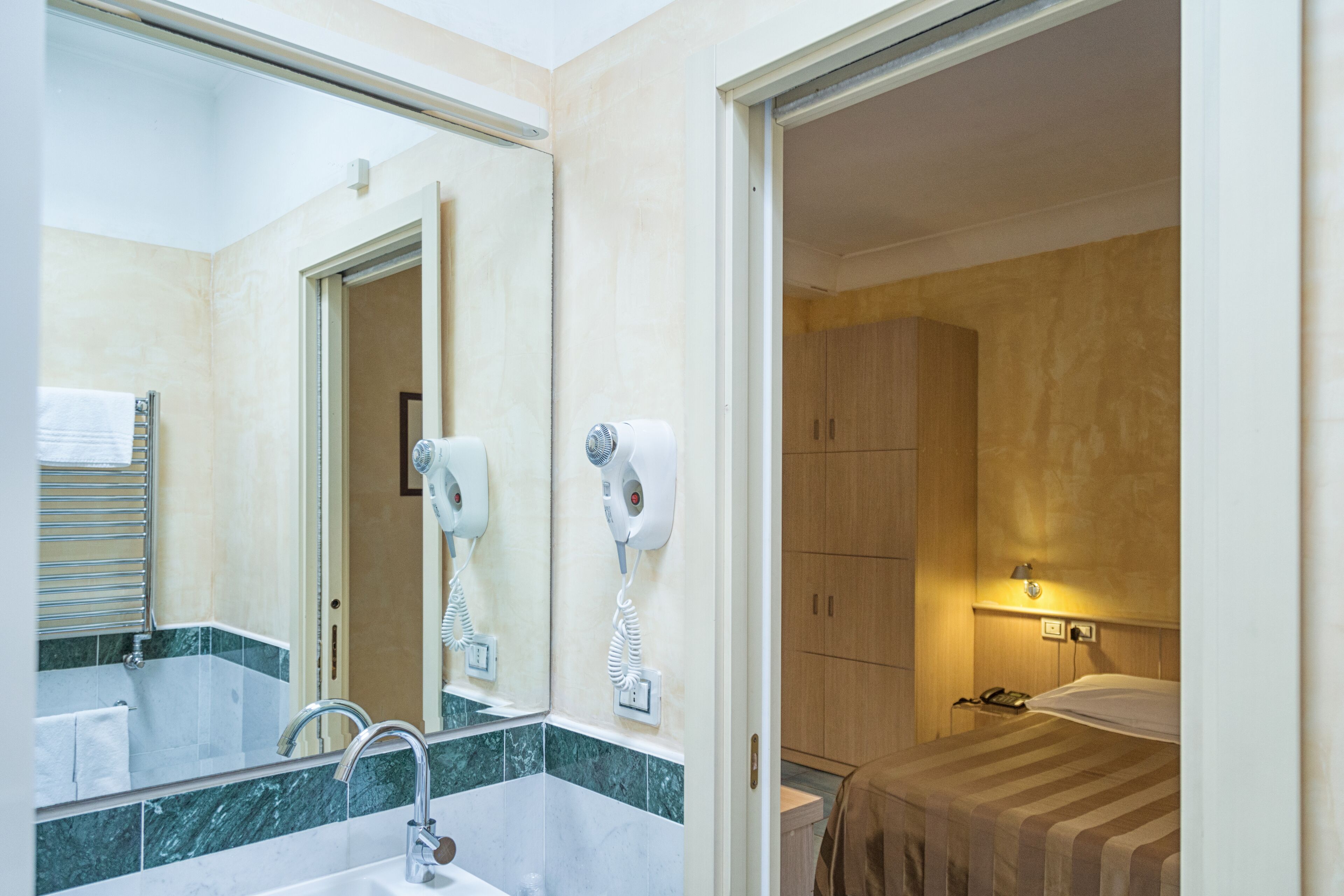 Un baño con lavamanos, espejo y secador de pelo.