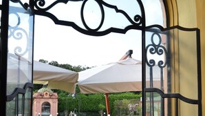 An outdoor dining area with a view of a garden and a fountain. - Villa Signorini Events & Hotel (Ercolano)