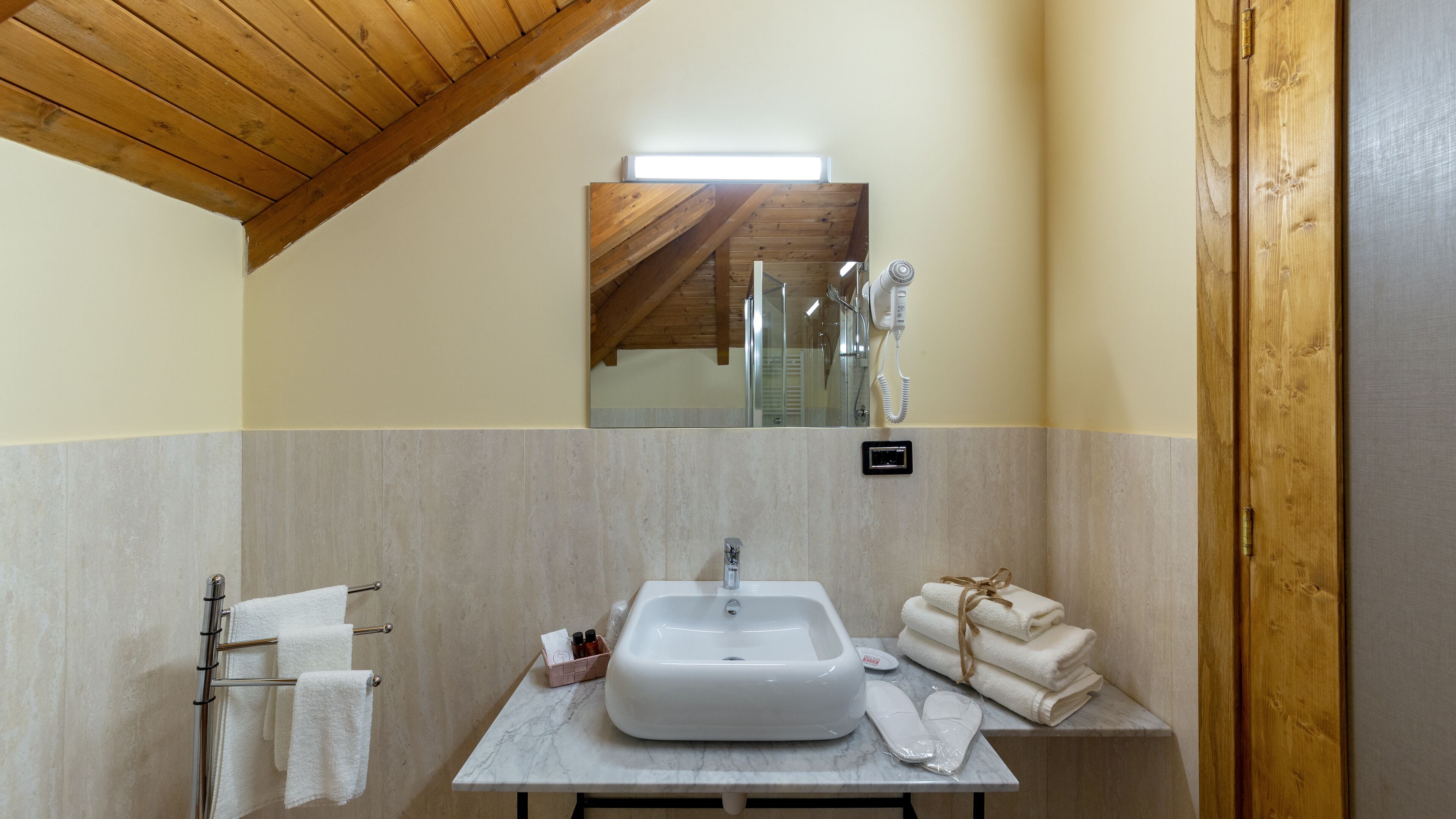 A bathroom with a marble sink, towel rack, and a mirror above the sink.
