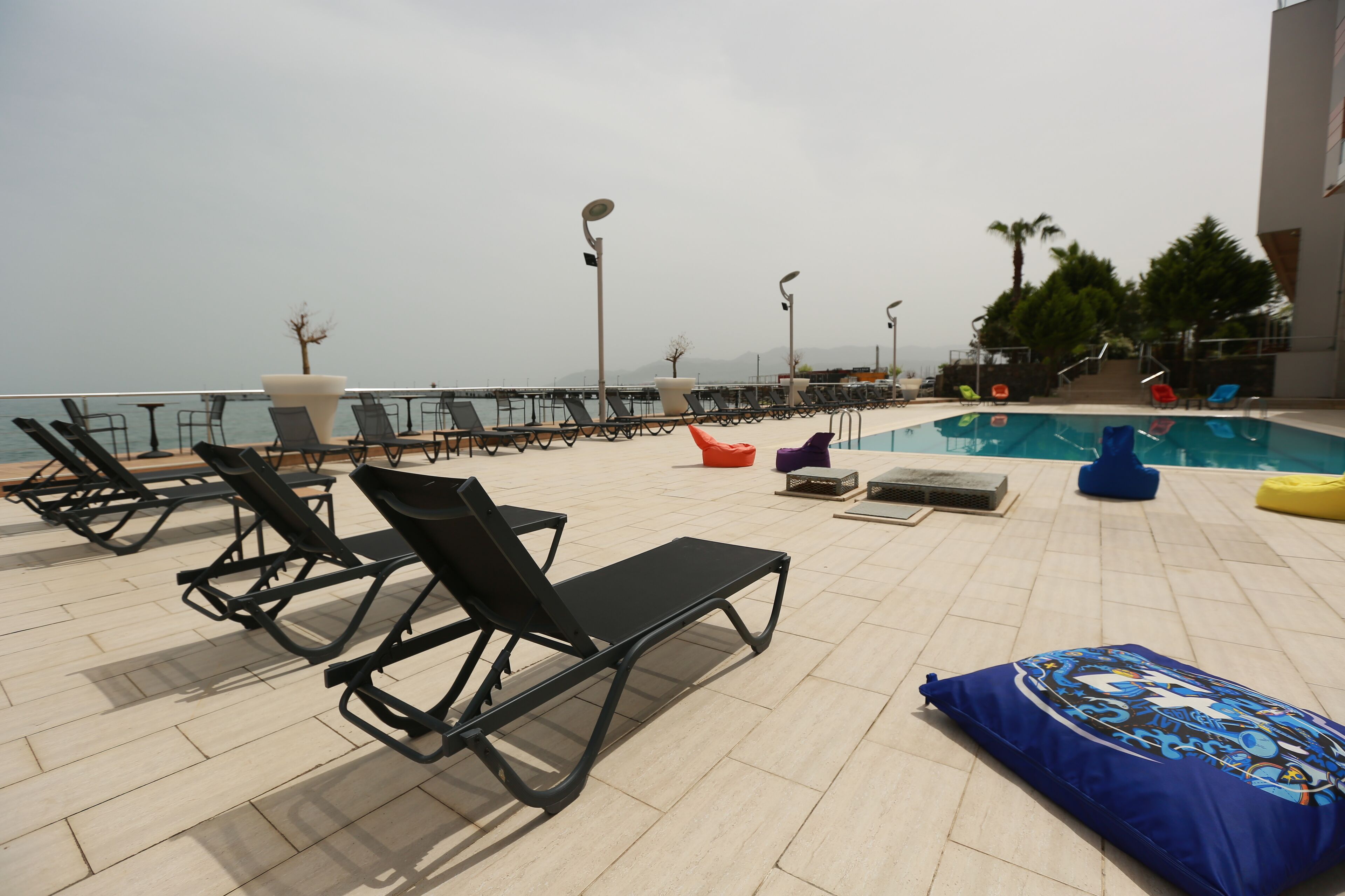 A rooftop pool area with lounge chairs and a swimming pool.