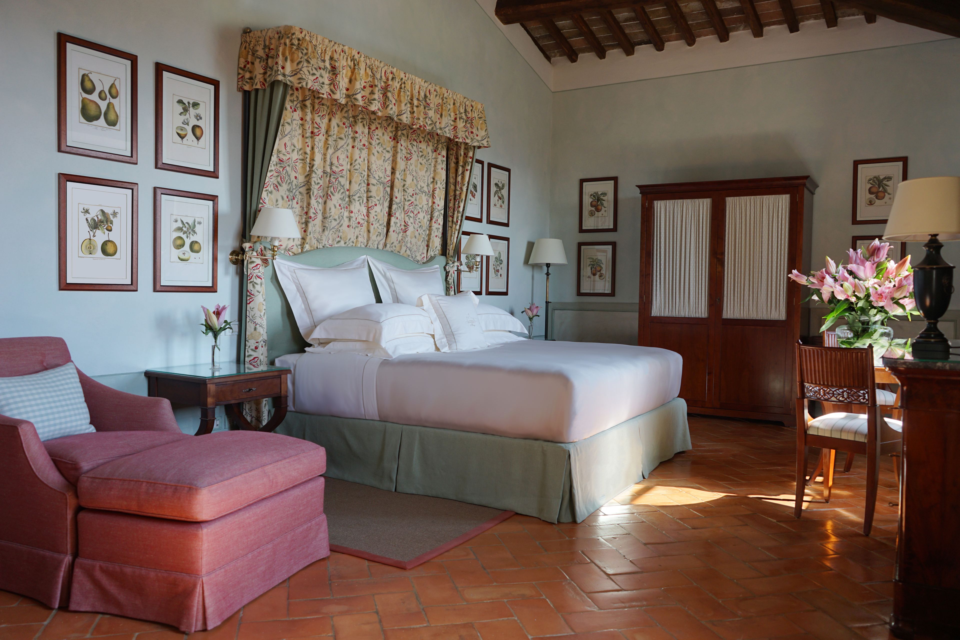Une chambre à coucher avec un lit, une chaise, une table de chevet et une lampe.