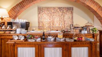 A buffet setup with various food items and a coffee station.
