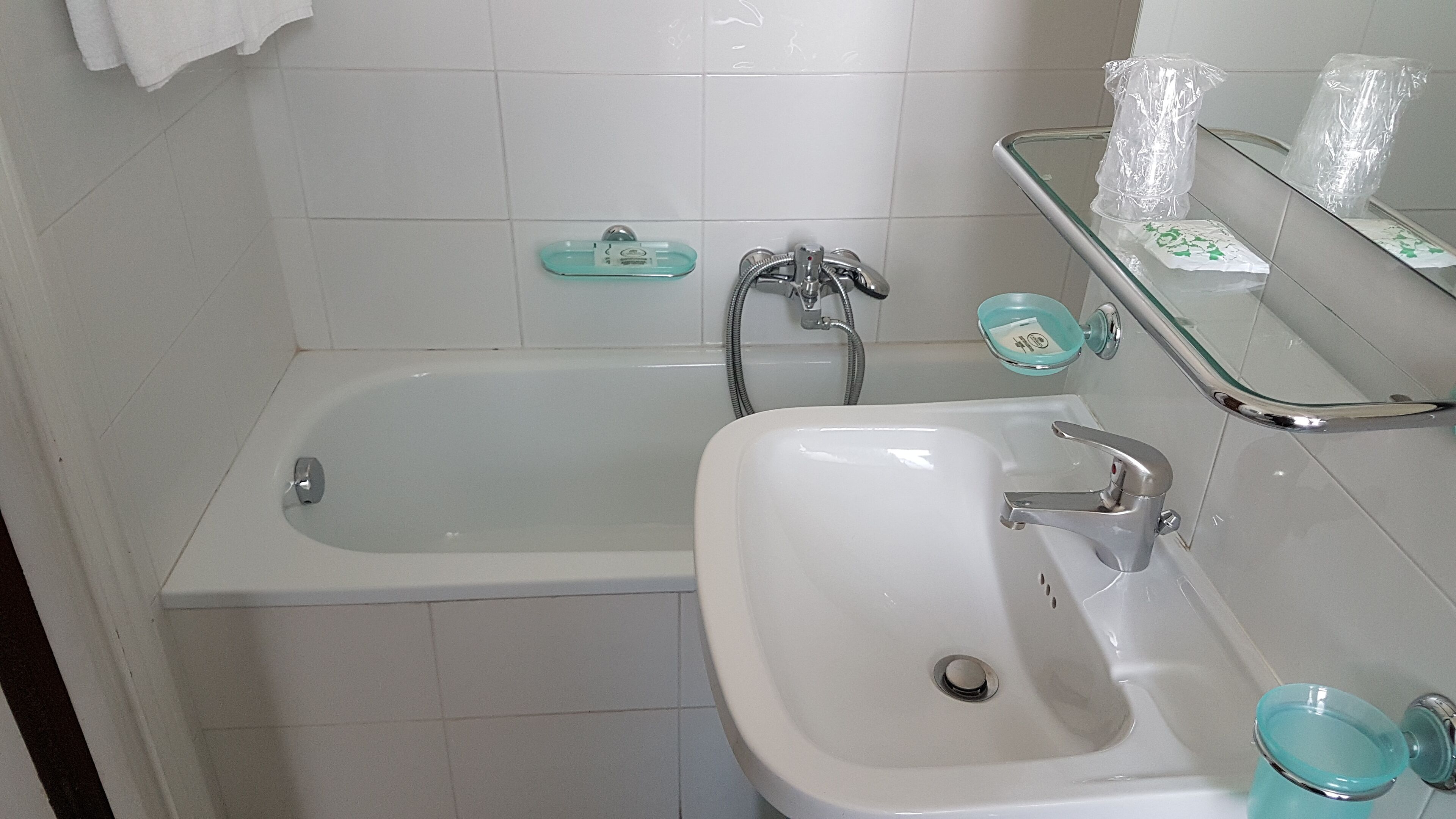 Un baño con bañera, lavamanos y plato de ducha de vidrio.