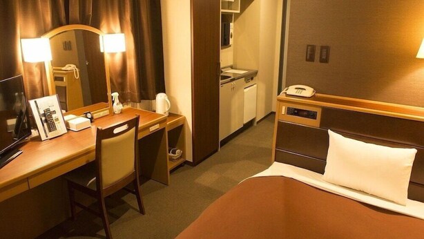 A hotel room with a bed, a desk with a chair, a telephone, a mirror, and a small kitchenette. - Nissin Namba Inn (Osaka)