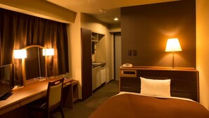 A hotel room with a bed, a desk with a chair, a mirror, a lamp, and a telephone. - Nissin Namba Inn (Osaka)